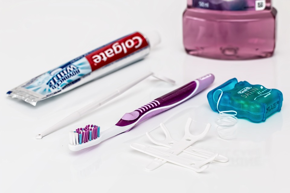 A collection of dental hygiene tools including a toothbrush, toothpaste, flossers, and mouthwash.