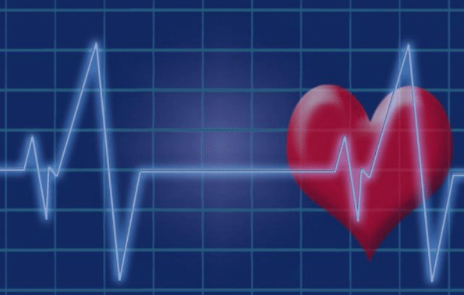 A red heart on an EKG line against a blue grid background.